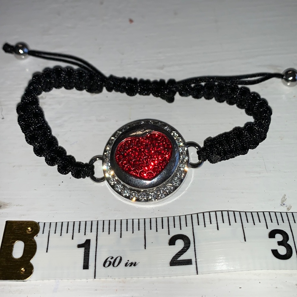 Adjustable braided black cord bracelet with one interchangeable snaps.NWOT